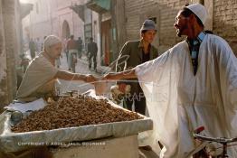 Image du Maroc Professionnelle de  Un commerçant ambulant expose ses noix sur un grand plateau dans une rue de la Médina de Marrakech à Bab Doukala, Dimanche 18 Août 1997. L'aire de production du noyer s’e?tend sur les cercles d’Asni, Amizmiz et Ai?t Ourir aux environs de Marrakech. (Photo / Abdeljalil Bounhar) 